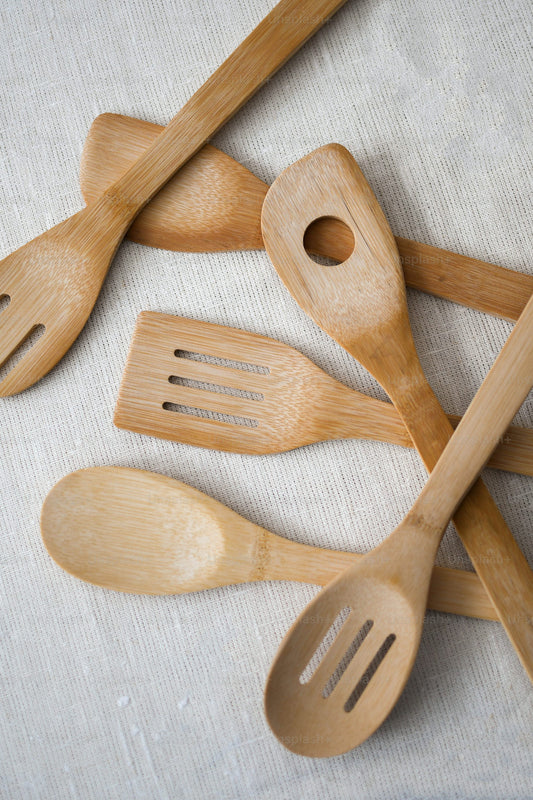 A pile of wooden utensils sitting on top of a table
